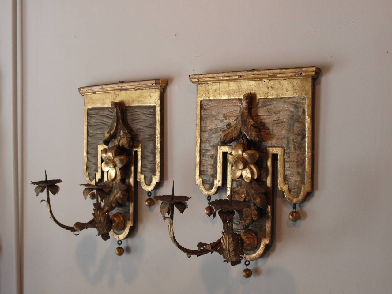 A stunning pair of Northern Italian Sconces - Appliqués - lacquered and water gilded.  The sconces have removable gilt iron arms.  The backplate is beautifully adorned with a wonderfully carved elegant floral motif - also water gilded.
