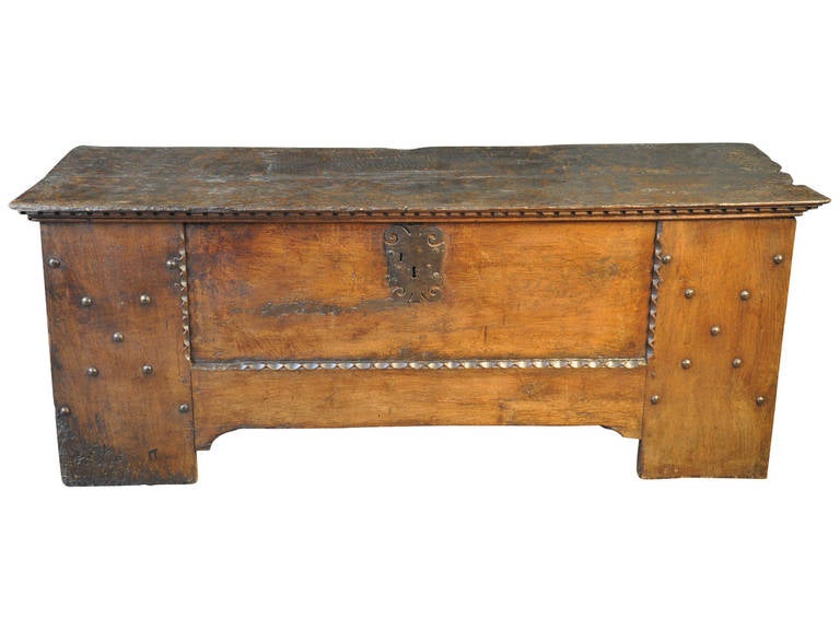 A very grand 17th century trunk - coffre - from Spain.  Beautifully constructed of Walnut with handsome wooden nail head detail, dentilated carving detail to trunk's lid.  This grand trunk would serve wonderfully at the base of a bed or as sofa