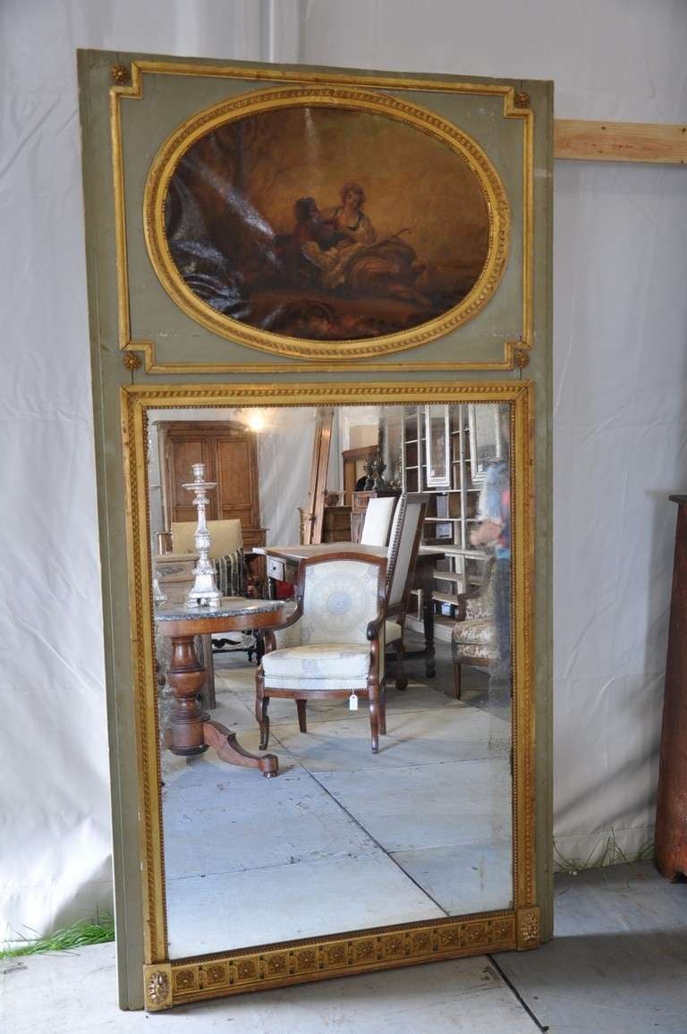 French antique Louis XVI style trumeau mirror in painted and gilded wood from the mid 19th century. This beautiful mirror features a painted scene of a pair of young lovers in a pastoral setting.