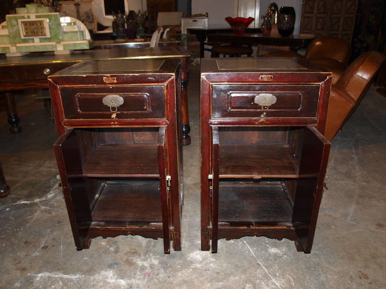 A wonderful pair of Chinese bordeaux lacquered side cabinets with Pudding Stone top inserts.  The cabinets are constructed from YuMu - Northern Elm Wood.  One drawer and one shelf behind the doors.  The pair also serves as excellent bed side