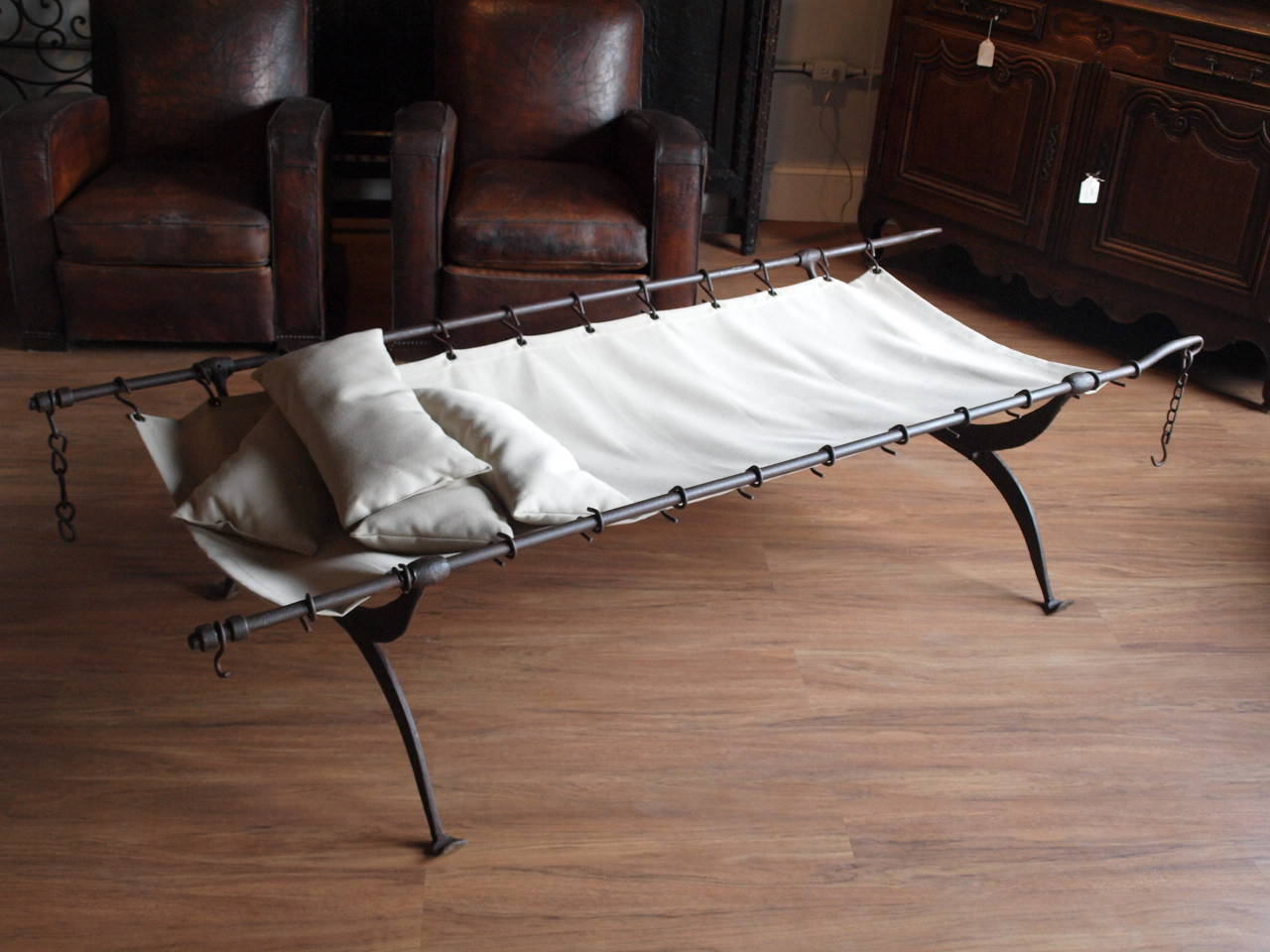 A rare mid 19th century collapsible French Campaign Bed constructed from hand forged iron - retaining its original surface.  This Campaign Bed is a wonderful accent piece - whether used as a chaise or converted into a terrific coffee table.  The