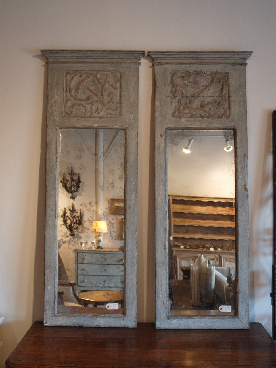 A lovely pair of painted Spanish Trumeau Mirrors constructed from 18th century Boiserie paneling.  The painted finish is in soft and warm tones of light grey.  The patina is textured and rich.  The price for the pair is $3624.  The pair may be