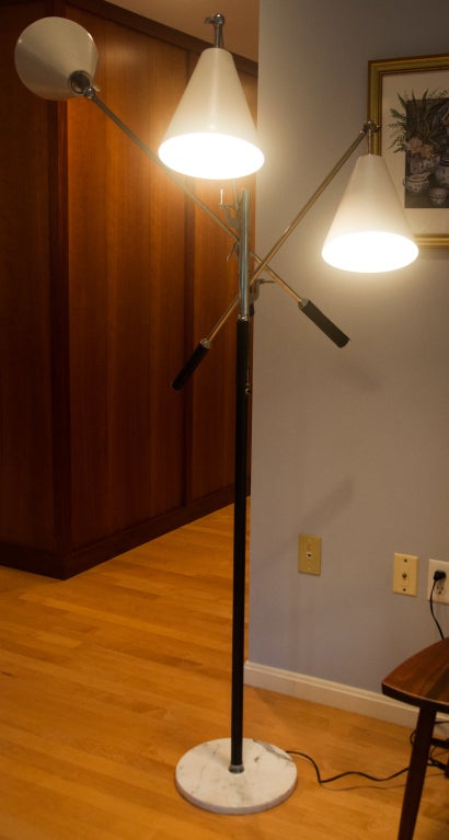 A gorgeous floor lamp designed in the mid 50s by Angelo Lelli. The lamp has 3 adjustable arms attached to an enameled stand on a round marble base. Each arm has a stitched leather handle.