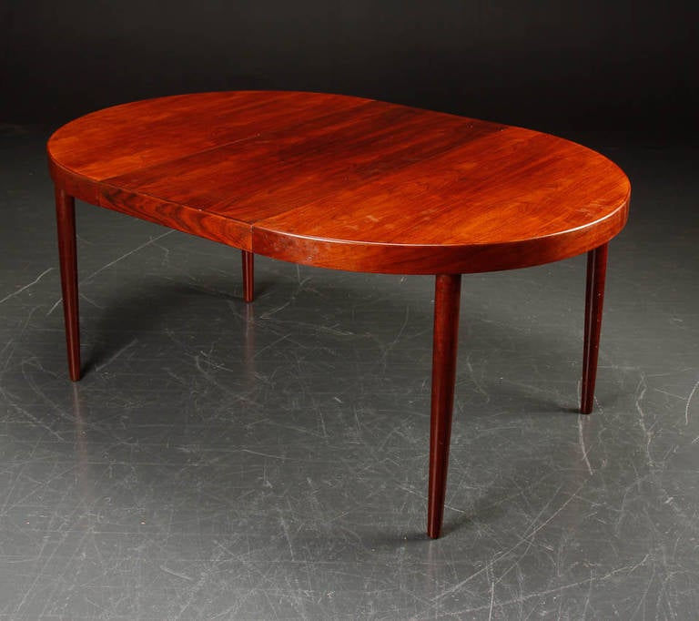 Elegant rosewood dining table with one extension.
