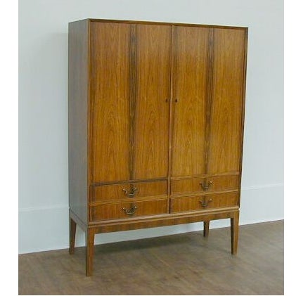 A tall rosewood cabinet by Ole Wanscher (attributed) for Andersen and Bohm. Cabinet includes original keys, 4 felt-lined drawers for silverware and 5 adjustable shelves.