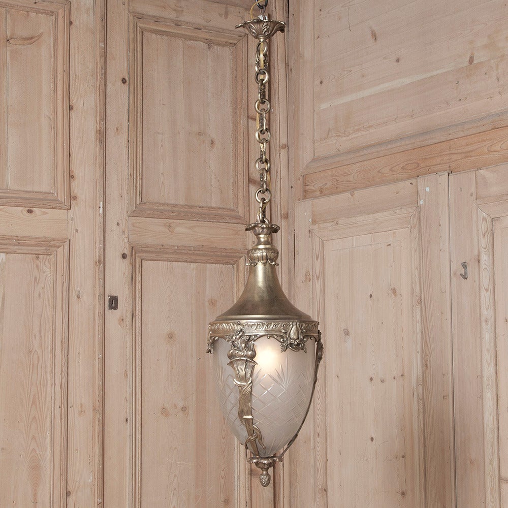 With a casing cast from bronze in a heraldic crest and torchere motif, this lantern chandelier survives with its original etched glass globe, chain and canopy!
Measures 19.5H x 9 in Diameter, 35H With chain & canopy
Circa 1910-1920