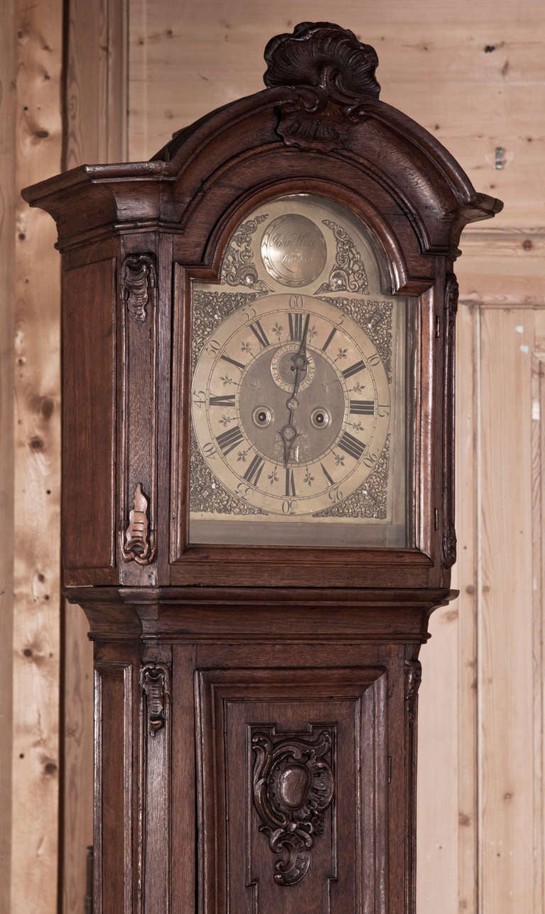 Featuring its original clockworks fabricated on the Swiss/French border, this superb long case clock boasts a case sculpted from dense, old-growth French white oak with Classic architecture enhanced by Rococo motifs rendered in fine relief. The