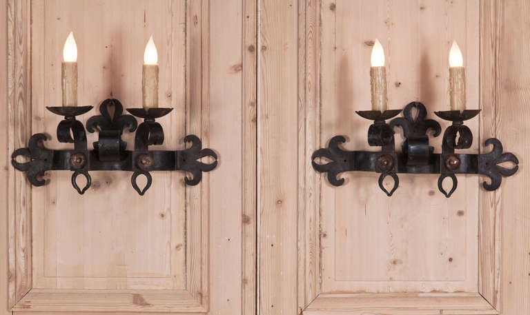 Pair of Country French wrought hand-forged iron sconces are great for the casual rustic decor! Stylized fleurs de lys add a special touch. Completely rewired with new sockets and candle sleeves, ready to hang,
circa early 1900s.
Each measures 15.5 H