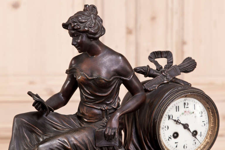 Antique French Louis XVI Mantel Clock features highly detailed cast spelter with a patinaed bronze finish set upon a footed marble base. Clock is restored to working condition. 
Circa 1890s. 
Measures 15H x 19.5W x 7D