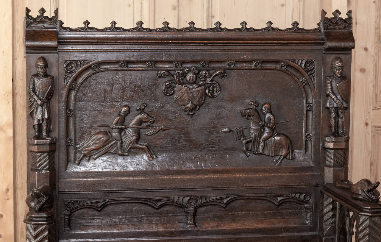 A remarkable testament to the sculptors who created this work, this 19th Century Gothic Hall Bench features a host of amazing motifs, from the jousting match to the knights flanking the scene on both sides, to the eels on the armrests, and gargoyles