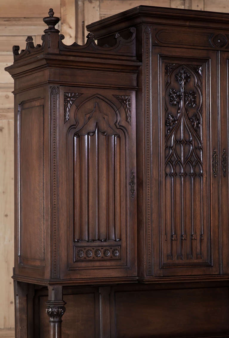 Hand-crafted from select French walnut, this impressive buffet features a generous serving area interrupted only by the column supports for the upper tier, which feature boldly carved capitals. The upper tier features finely detailed panel work