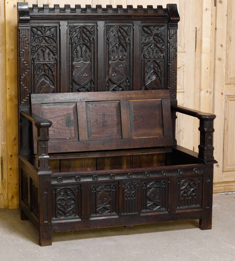Sculpted from old-growth French oak in a definitive representation of the timeless Gothic style, this Antique French Gothic Hall Bench also works well in libraries and masculine-oriented decors. 
Circa 1870s. 
Measures 59.5H x 51W x 19.5D; seat