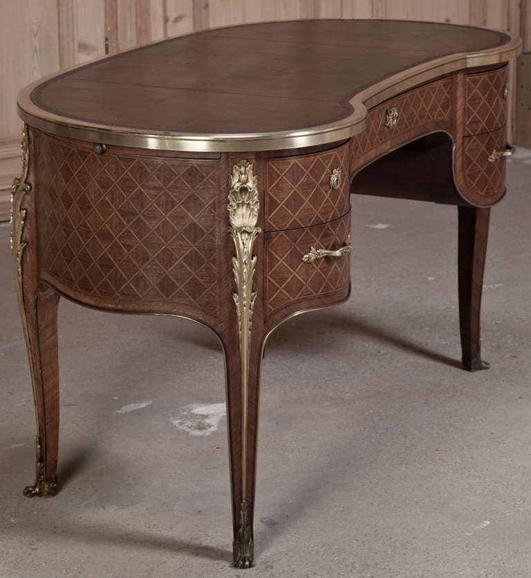 This remarkable work of art features the talents of master Italian cabinetmakers and metalsmiths, joining forces to create a unique treasure! Using fine imported mahogany, satinwood and walnut, an intricate casework in kidney shape was formed, with