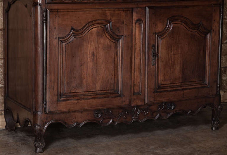 Soaring over eight and a half feet tall, this impressive vaisselier was meticulously hand-crafted from select French walnut, and features timeless Louis XV-inspired styling from the chapeau de gendarme cornice to the scrolle legs below. Gracefully