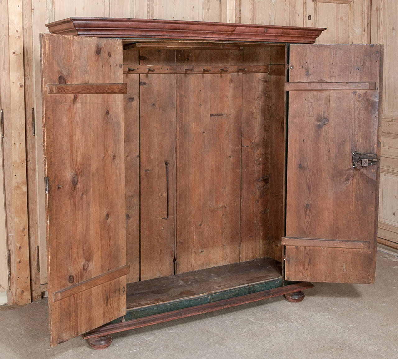 The stately, tailored lines of Swiss furniture always provides a versatility and this armoire is no exception. Handcrafted in the early 1800s, it has been fitted with a pair of doors mounted on intricately hand-forged steel strap hinges, with steel