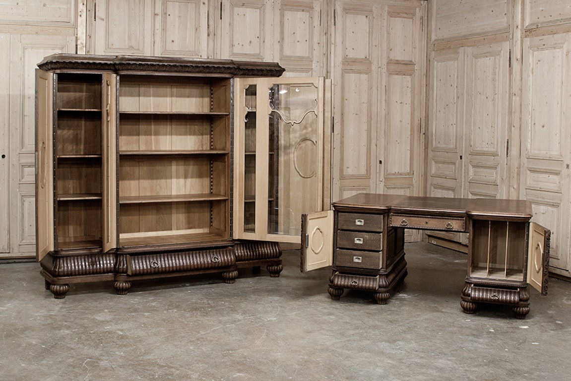 Carved with elaborate Renaissance Revival motifs on the cabinet panels, this handsome desk and bookcase set are perfect for an Old World touch!  The beveled glass door at the center of the bookcase is framed by “side lights”, then by the beautifully