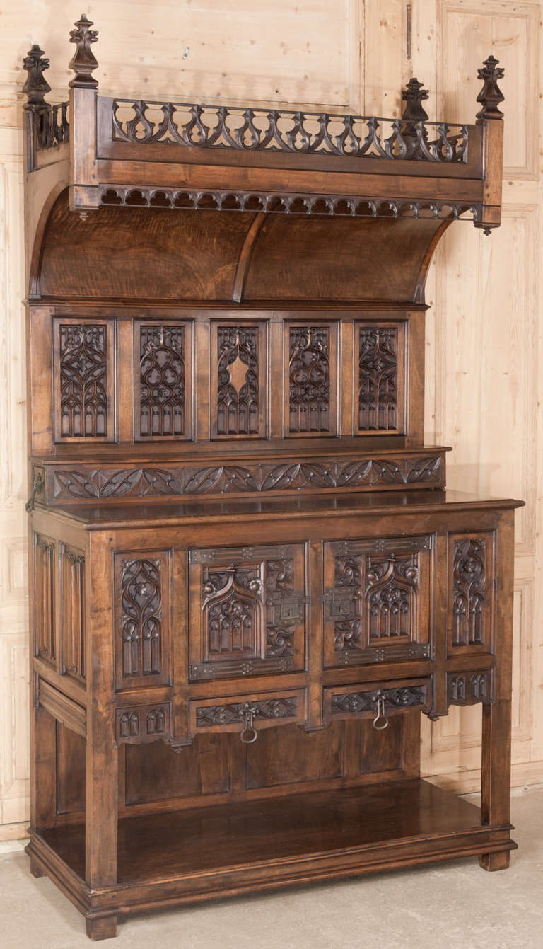 Sculpted from solid French walnut in the timeless Gothic style during the revival of the mid-19th century. 
Circa 1850. 
Measures 103H x 57.5W x 25D; buffet 45H; buffet 45H