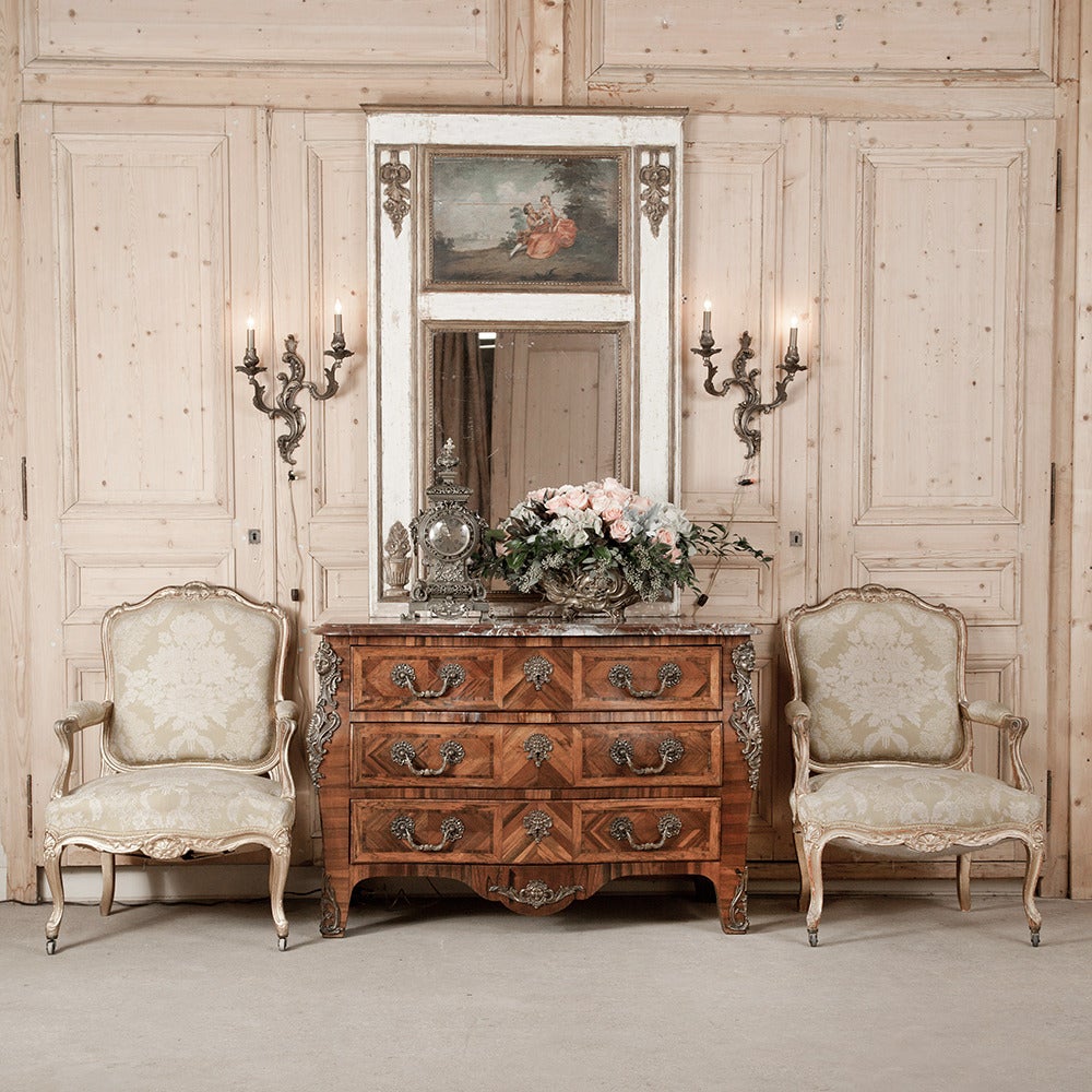 Luxuriously crafted in a style that originated with the splendor of the reign of Louis XIV, this stunning 19th century kingwood commode features a contoured facade lavished with exotic wood marquetry in a parquet like pattern, bronze ormolu mounts,