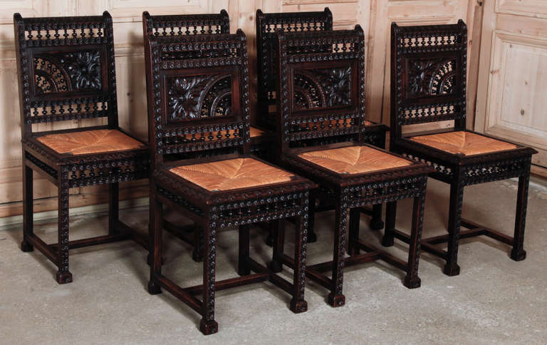 In a departure from more traditional furnishings from Brittany, this set of chairs features asymmetry in the seatback combining a quarter circle of double-tiered spindle rail with a large rosette. Spindle rails appear across the top and bottom of