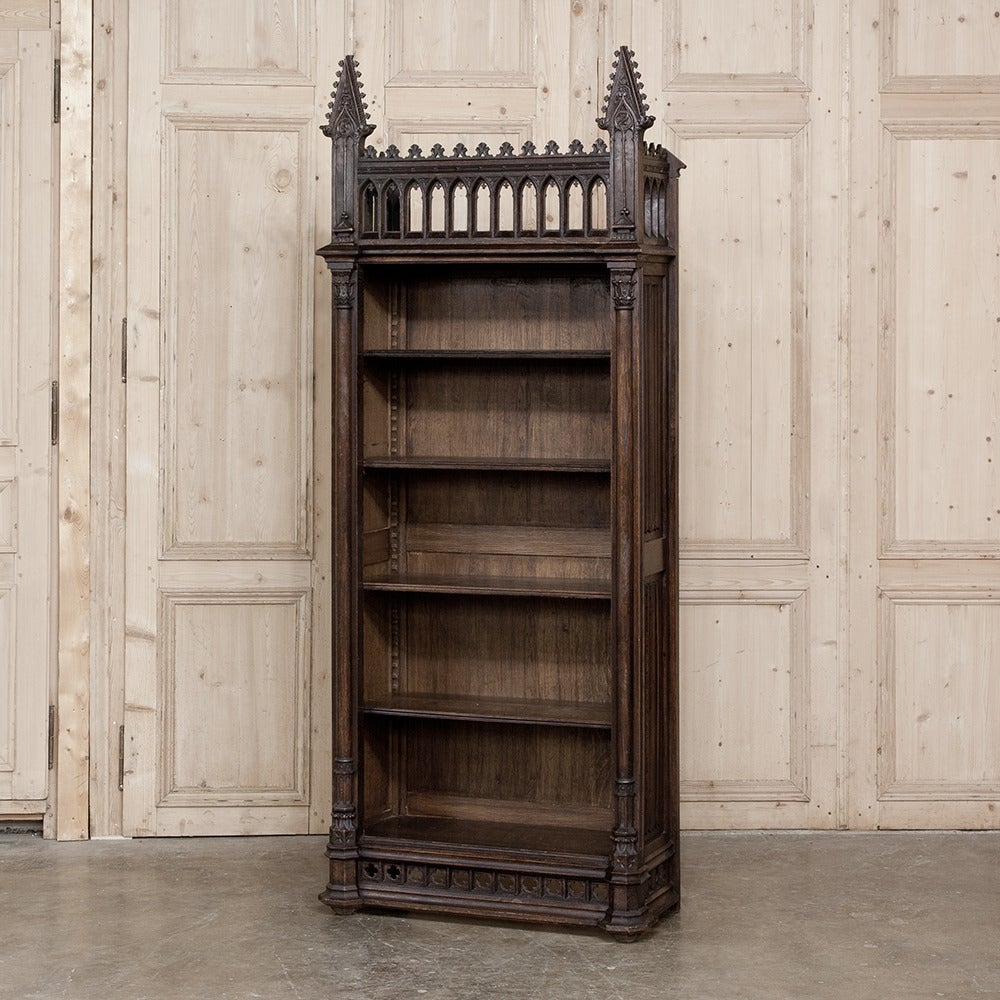 This intriguing 19th century Gothic open bookcase was crafted from dense, old-growth oak for generations of service and designed on a diminutive scale making it a perfect choice for a tight spot or cozy niche. The high spires on each corner post are
