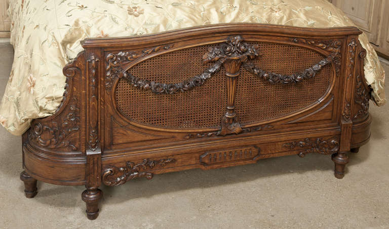 Exceptional hand-carved detail, rounded footboard, and the rails have been extended to accommodate a Queen size mattress set! 
Circa 1870s. 
Headboard measures 66H x 64W; footboard measures 32.5H x 63W; rails to be extended to accept queen size.