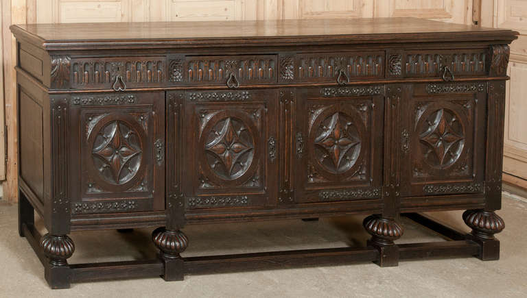 A splendid example of the last revival of the Gothic and Renaissance styles of late 19th century Europe, this superb Antique French Raised Buffet was sculpted from old growth French oak and fitted with finely detailed iron strap hinges, keyguards