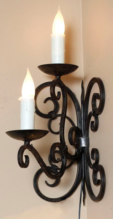 No, your eyes do not deceive you, this is a set of four matching corner wall sconces! Hand-forged from wrought iron, they were designed to illuminate a switchback staircase. Each will be electrified upon arrival stateside by our expert in-house
