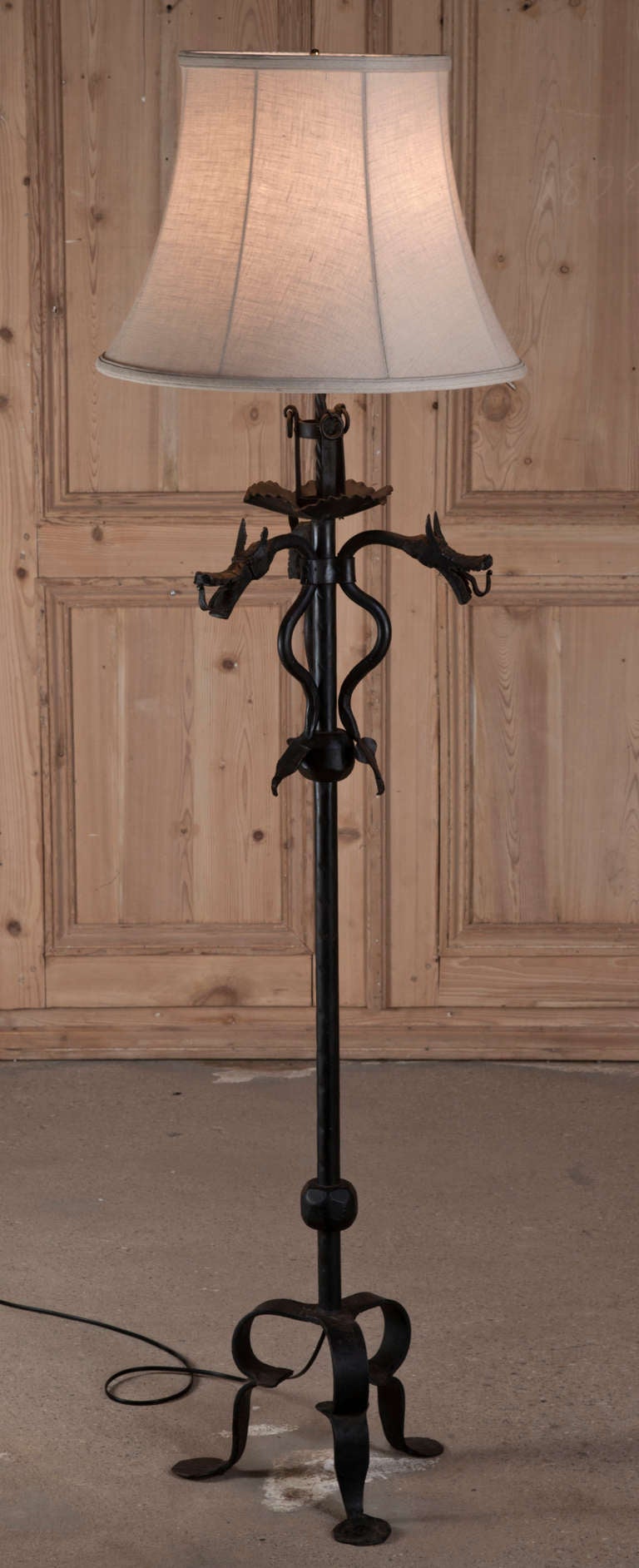 With three fearsome dragons above and a tripod footed base below, this heavy wrought iron floor lamp will be perfect for adding a medieval touch to your decor. Originally used for candles, it has now been wired to UL Standards and fitted with a