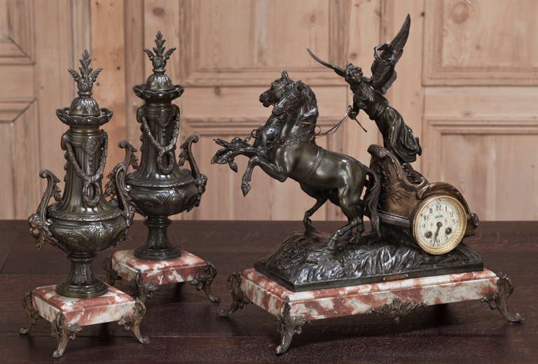 This magnificent work, cast in spelter and given a multi-hued patinaed bronze finish, depicts an angel trumpeting her entrance atop a finely crafted chariot drawn by a brace of robust stallions. The chariot serves as the housing for the working