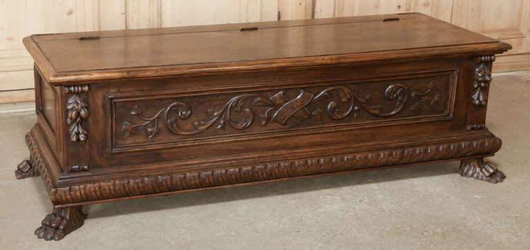 The perfect piece for the foot of the bed or along a hallway.  Lion's paw feet combine with relief carvings across the facade with boldly molded base.  Top lifts open for surprising storage!
Circa early to mid-1900s.
Measures 20H x 66W x 22D