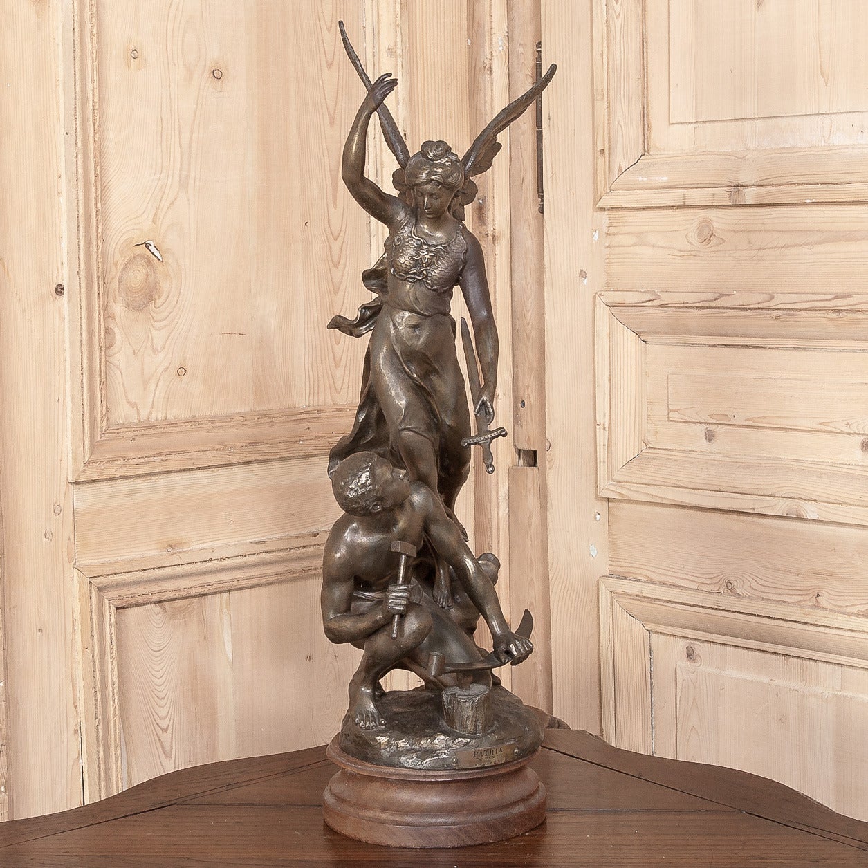 A spelter rendition of the bronze statue that won sculptor Charles Vely a gold medal at the Paris Exposition, this work glorifies the work of the farmer or artisan tool maker in their roles of supporting the patriotic goals of the French