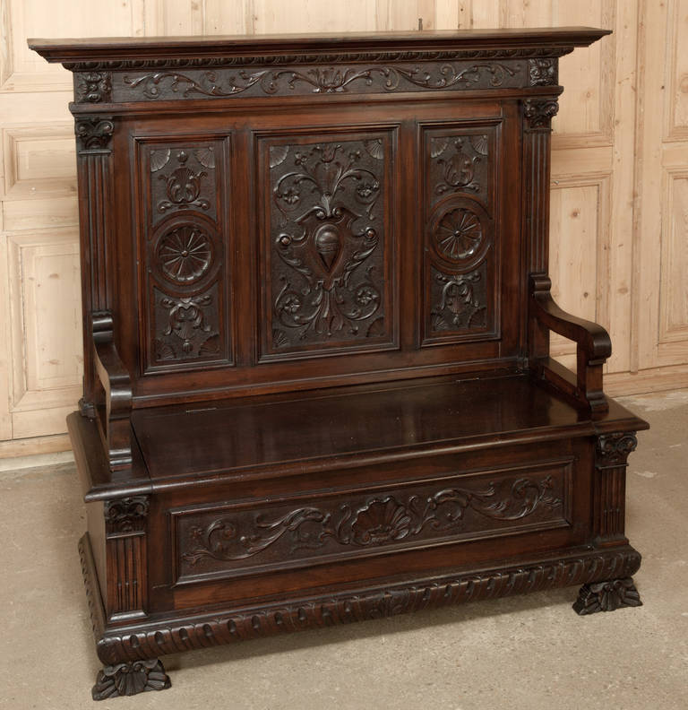 The perfect way to greet all who enter your home or business in fine Italian style, also great as a bench for any room, this Antique Italian Renaissance Walnut Hall Bench even has storage under the seat. 
Circa 1890s. 
Measures 53 x 57 x 19.5;