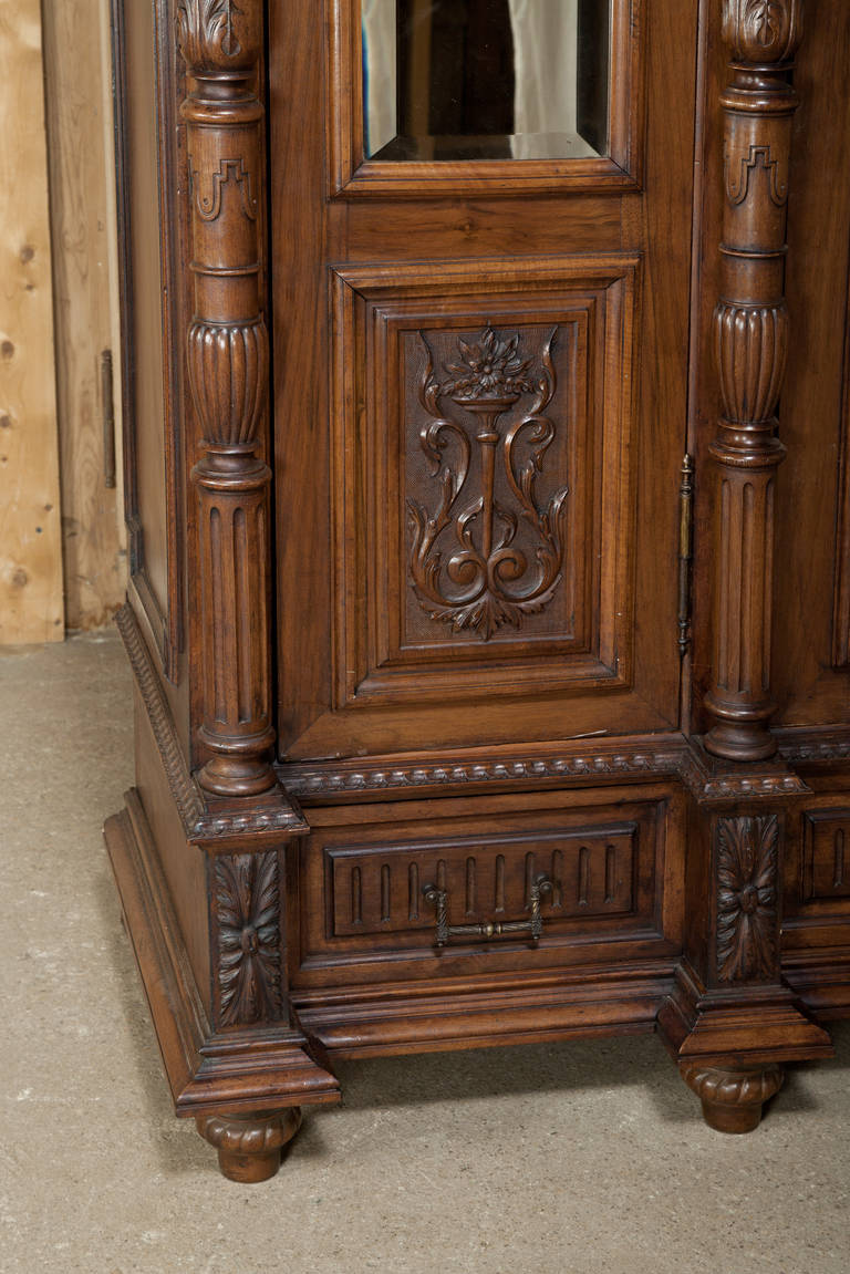 Antique French Henri II Walnut Triple Armoire features stately, timeless architecture, generous original beveled mirrors, and abundant storage in Old World style! Circa 1870s. <br />
Measures 103H x 74W x 22D.