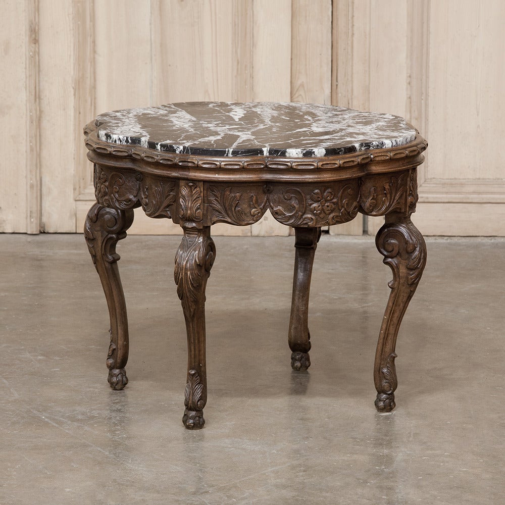 With a top shaped like the petals of a flower, this intriguing antique Louis XIV style end table features a superbly fitted marble top and beautifully carved apron, all supported by scrolled legs for a truly timeless look.
circa 1880s.
Measures