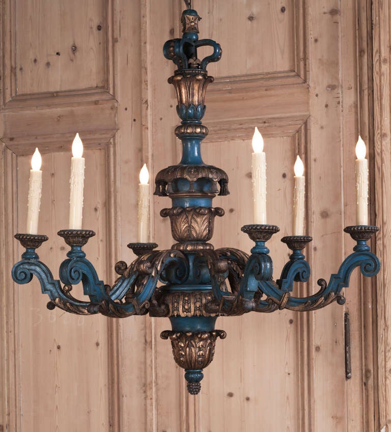 Hand-carved in the regal manner of Louis XIV, then given a two-toned painted finish which has achieved a lovely patina over the decades, this chandelier is perfect for the Paris Country or 