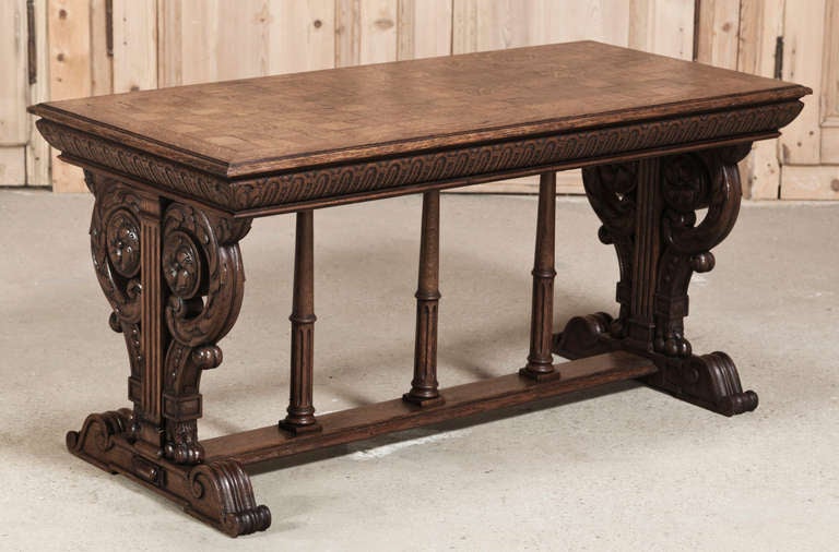 Antique Italian Renaissance style coffee table rendered entirely of oak with parquet top, scrolled & carved supports.