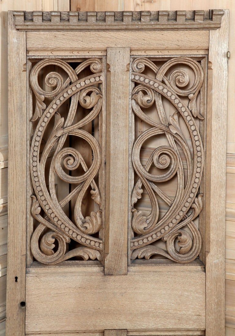 Hand carved from solid French white oak, this Gothic style door features an elaborate foliate design pierce-carved through the top two panels, with chamfered panels below. Castellation molding at the top adds an interesting touch. A perfect door