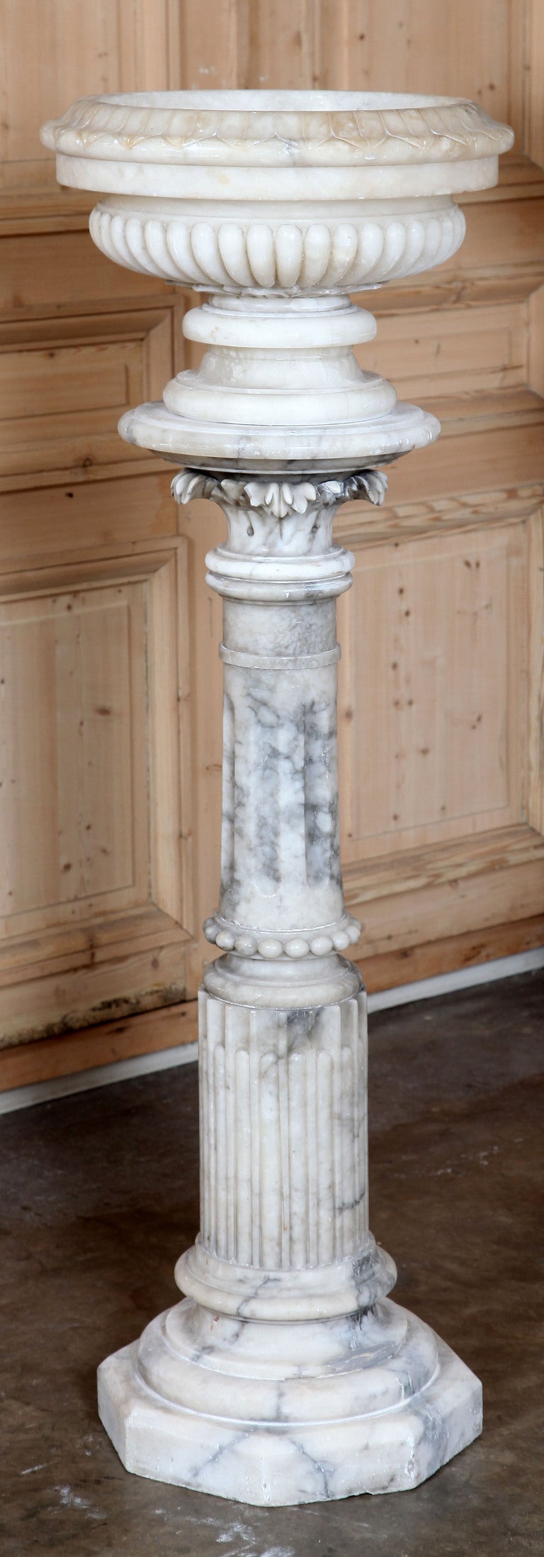 Amazingly enough, the original antique Italian Cararra marble urns that were designed to top this pair of exceptional solid Cararra marble fluted pedestals have remained together, making the two pieces exceptionally unique! Classic Greek revival