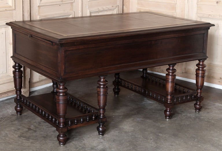 Crafted from fine French walnut, this handsome desk has been finished on all four sides, and features a gallery rail around two lower shelves, keeping your work much more handy than stashed in a cabinet. Five traditional drawers and carvings of