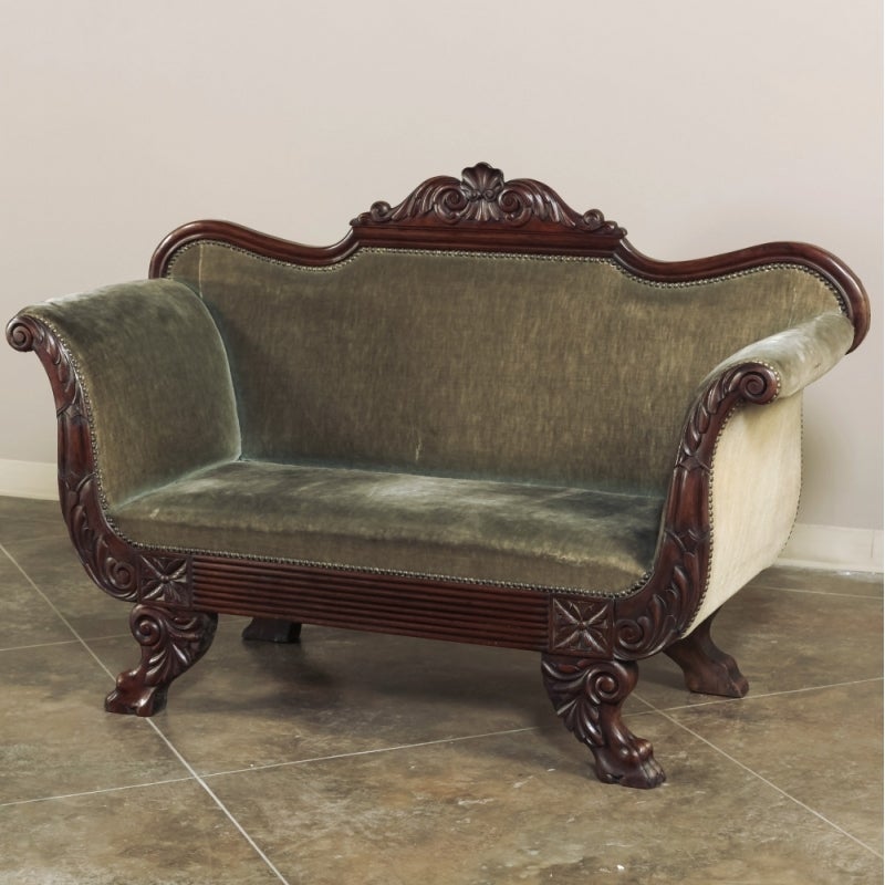 Combining lion's paw feet with glorious acanthus flourishes, this elegant antique sofa, or canape, boasts bold carved rosettes, scrolled armrests and a seatback crown that is a work of art! Considered not only as seating, such works were designed to