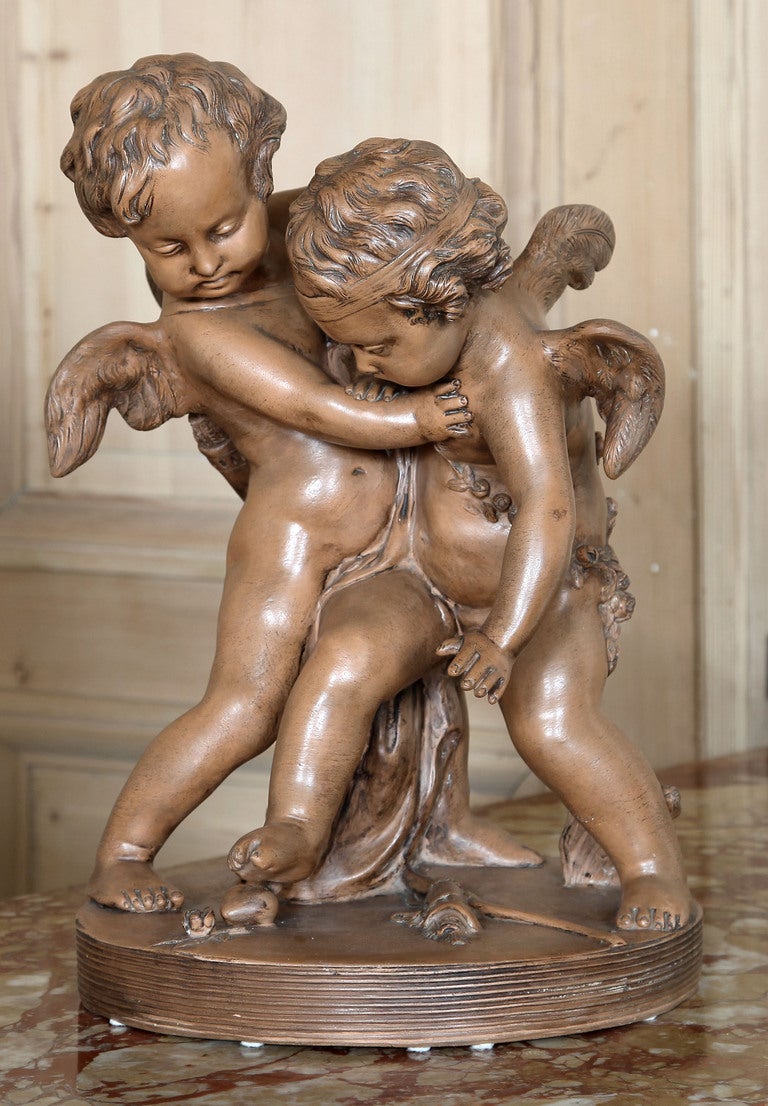 Depicting Cupid entreating a fellow cherub to refrain from breaking someone's heart, this pair of timeless figures have been immortalized in many media, and in this case terra cotta which has achieved a stunning patina over the past century. St.