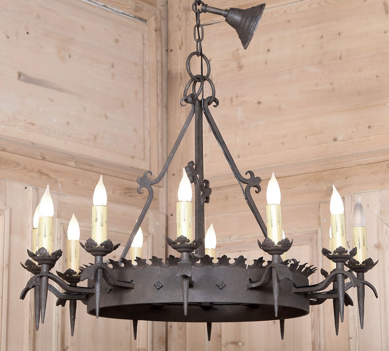 Forged from solid iron in a rustic Gothic style, this heavy chandelier is perfect for the country home or provincial decor! No less than a dozen chandelles ensure plenty of light will be cast by the newly wired fixture, which survives with a short