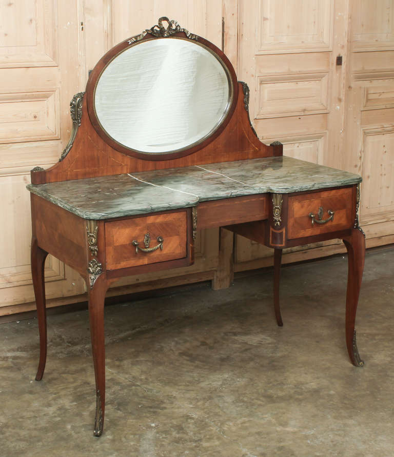 Mahogany with cast brass pulls, keyguards and ormolu mounts, original beveled mirror and beveled marble top. 
Circa 1900-1910. 
Measures 53.5H x 45.5W x 22.5D; Surface 30.5H