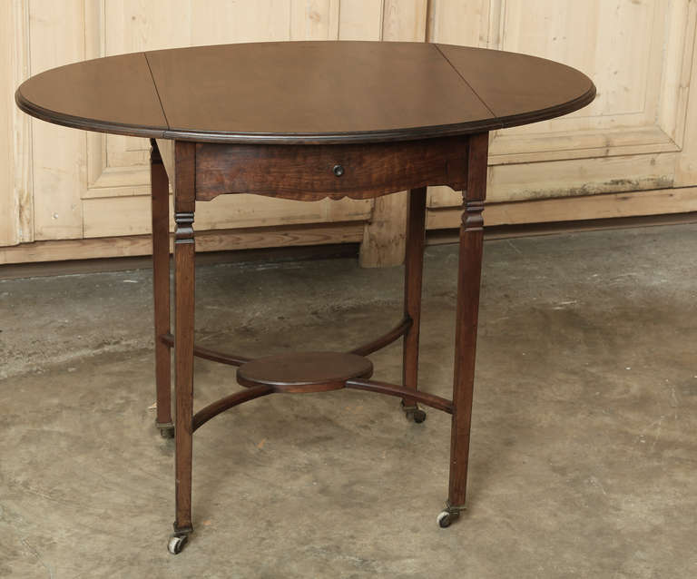 Perfect for your favorite seating group, this Antique English Drop Leaf Tableincreases in size to one and a half times its 