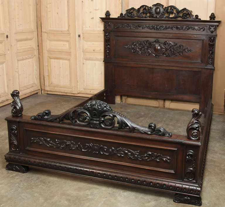 Benchmade from fine Italian walnut and hand-carved with a glorious expression of Renaissance-inspired embellishment in full relief, this bed has been custom-extended by our expert in-house staff to accept a California King mattress set! 
Heraldic