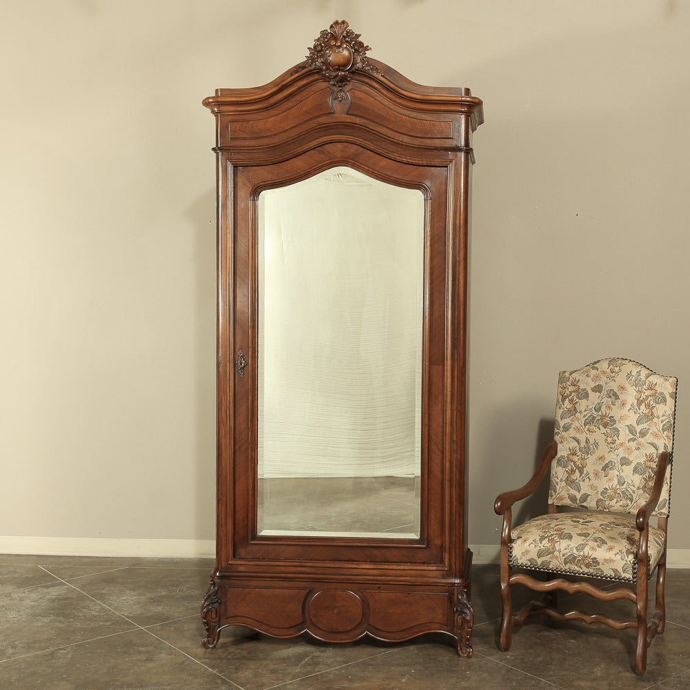 This 19th century French Regence walnut armoire was handcrafted during the transition between the Louis Philippe and Napoleon III periods, and represents the epitome of French master craftsmanship! Sculpted from fine French walnut and fitted with