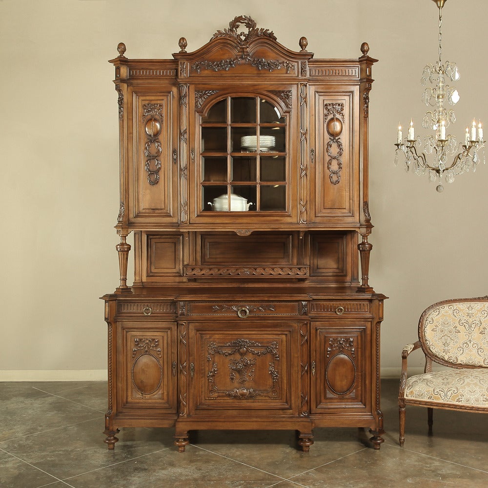 Grand 19th century French walnut neoclassical China buffet soars to 111 inches high and features its original 12 beveled panes at the center top for display. Note the arbalette (Archer's bow) crown centered with a laurel wreath and sprays on this
