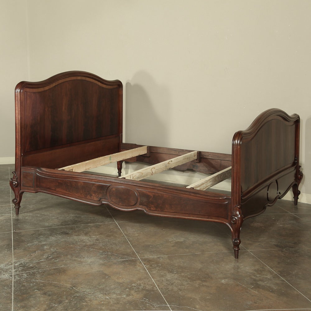 Handcrafted from exotic flame mahogany during the Louis Philippe Period, this antique California king bed has had its rails extended by our expert in-house customization staff to accommodate a California king mattress set! The simplicity of the