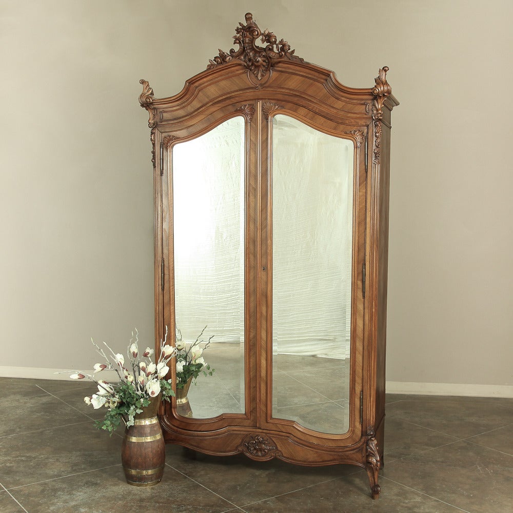This stunning 19th century Rococo French walnut armoire features hand-craftsmanship from select French walnut with original full length beveled mirrors and finely finished interior to match the beautifully sculpted exterior! An amazing artifact from