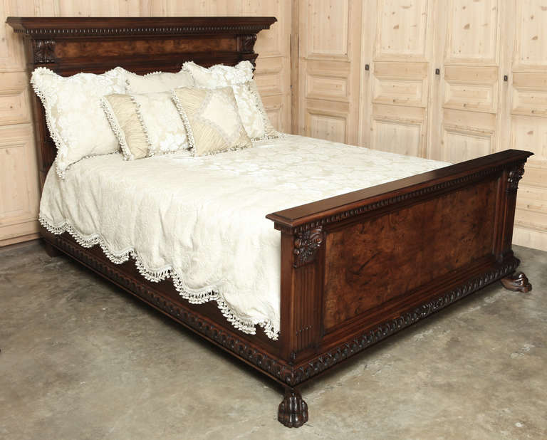 Featuring a framework of exquisitely carved Italian walnut surrounding panels of contrasting bookmarked burl walnut, this bed boasts the stately architecture inspired by the glory days of ancient Greece and Rome. Boldly fluted pilasters crowned with